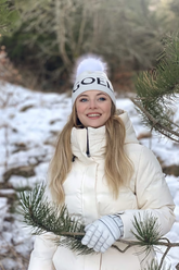 a lady in a white coat and a white knit hat